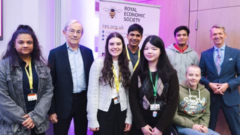 Royal Economic Society Annual Lecture speakers Sir Chris Pissarides and Andrew Haldane CBE pose for a photo with a group of sixth-form student attendees.